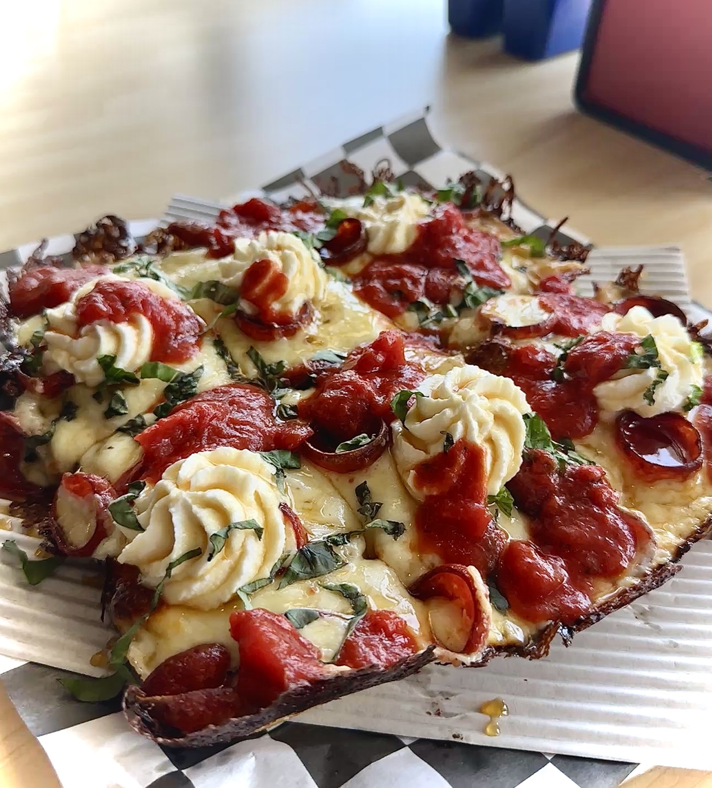 Detroit-style pan pizza with ricotta dollops, basil, pepperoni, and crushed tomato from Uncle G's